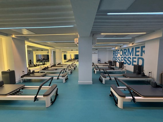 Vista interior de una sala de entrenamiento equipada con maquinaria Reformer